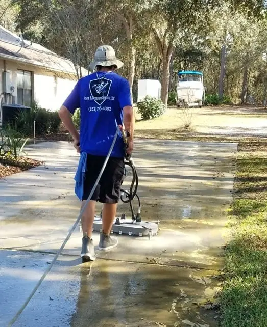 Driveway cleaning service removing dirt and stains with professional pressure washing